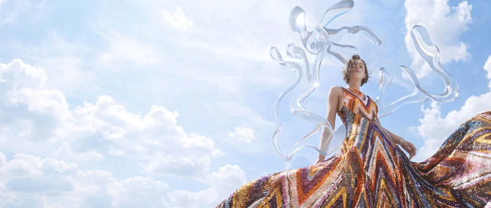 A woman in a flowing Missoni dress against an open sky